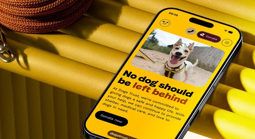 Dogs Trust promotional image with mobile phone displaying the website